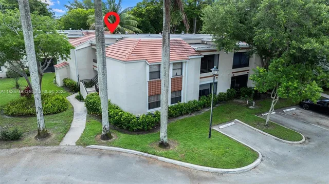 an aerial view of residential houses with outdoor space and trees
