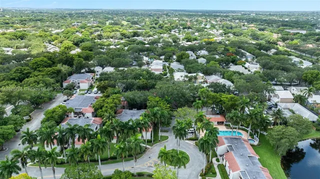 an aerial view of residential houses with outdoor space and lake view