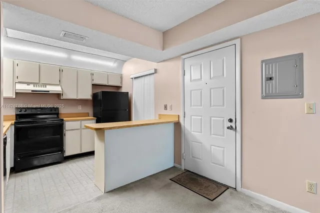 a kitchen with white cabinets and black appliances