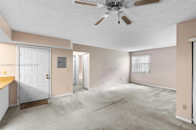 an empty room with fan and windows