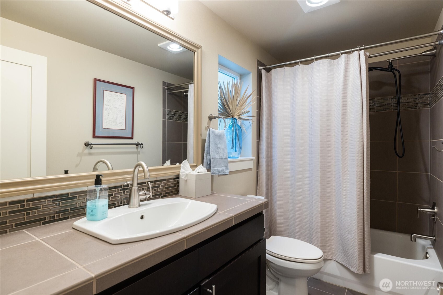 3414 33rd Avenue Southwest Seattle, WA 98126 - Photo 23 of 26 a bathroom with a sink a toilet a mirror and shower