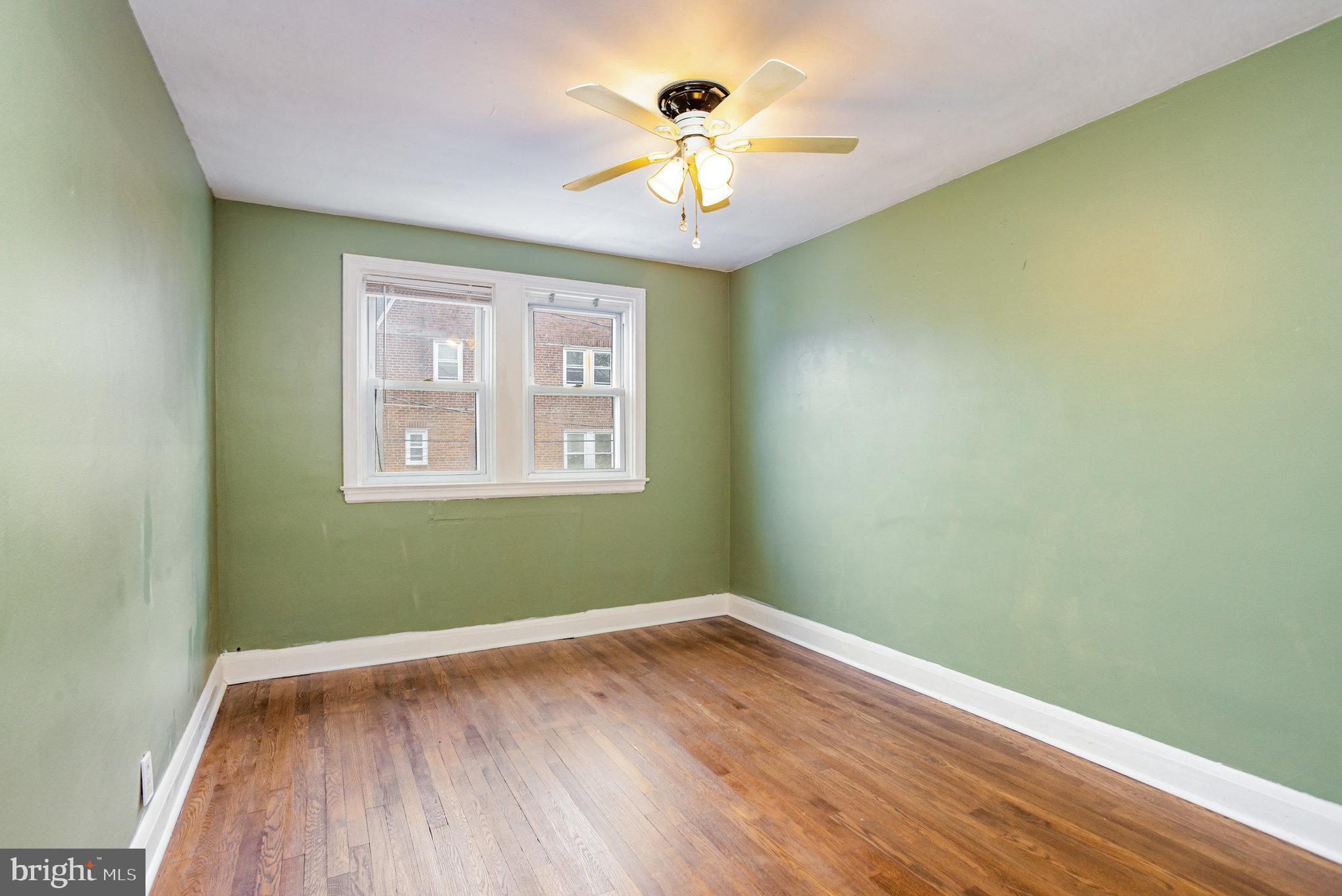6203 Frederick Road Catonsville, MD 21228 - Photo 8 of 24 a view of a room with wooden floor and a ceiling fan