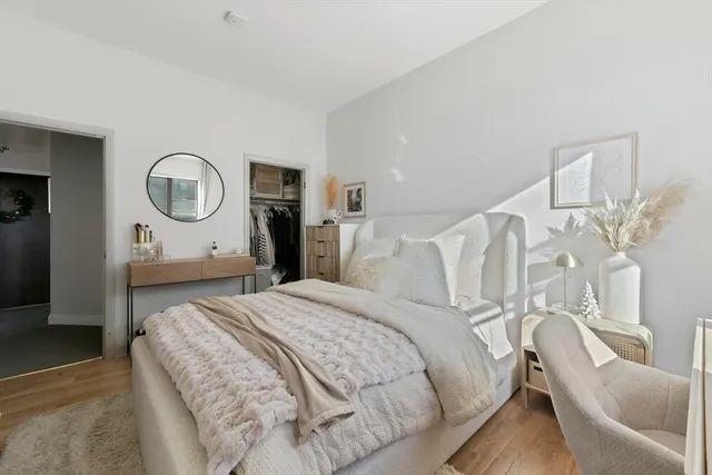 a bedroom with a bed mirror and white walls