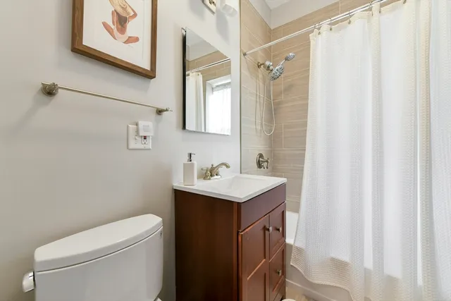 a bathroom with a sink a toilet and shower curtain