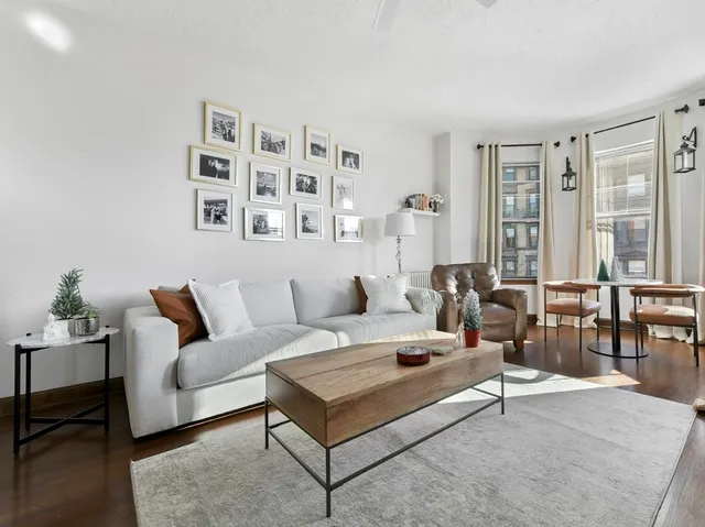 a living room with furniture a rug and white walls