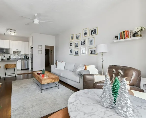 a living room with furniture and a dining table with kitchen view