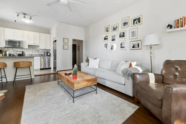 a living room with furniture and a dining table with wooden floor