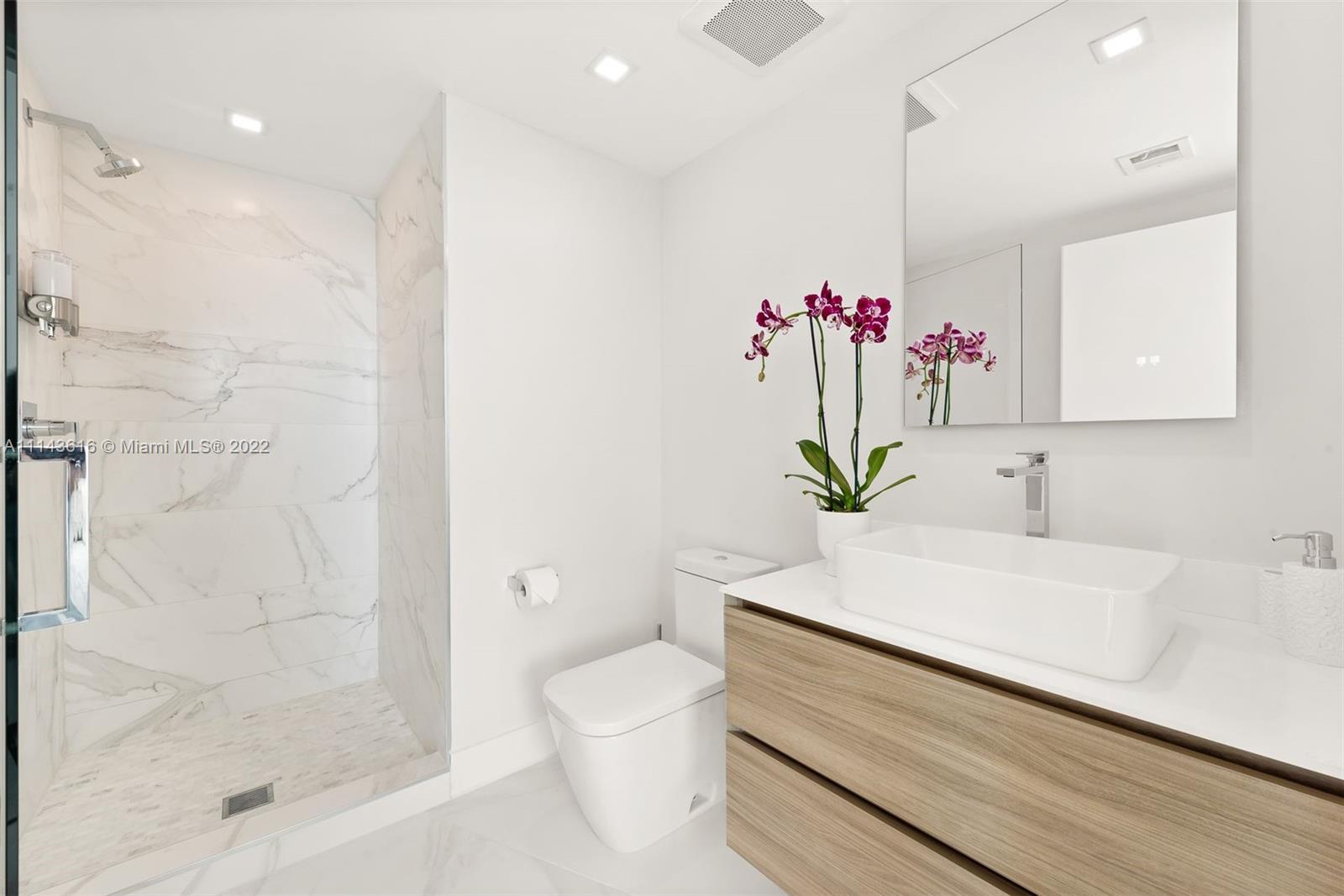 450 Alton Road, Unit 2301 Miami Beach, FL 33139 - Photo 13 of 21 a bathroom with a sink a toilet and a shower