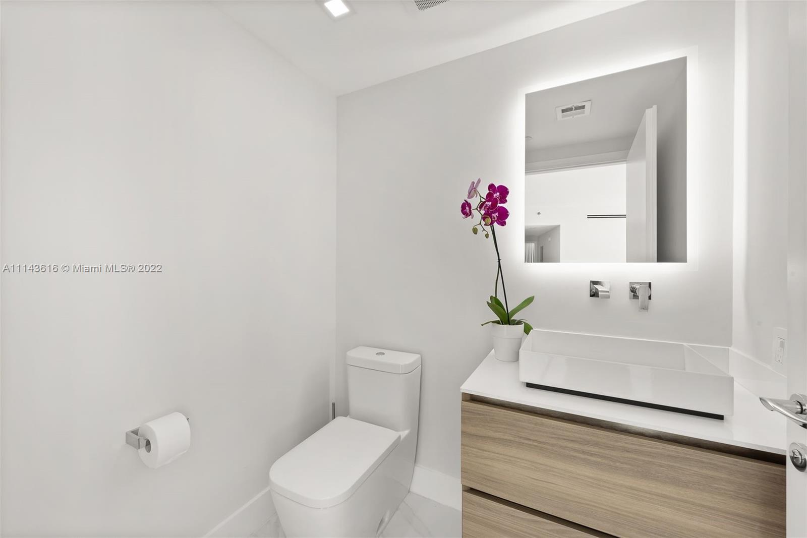 450 Alton Road, Unit 2301 Miami Beach, FL 33139 - Photo 15 of 21 a bathroom with a sink a toilet and mirror