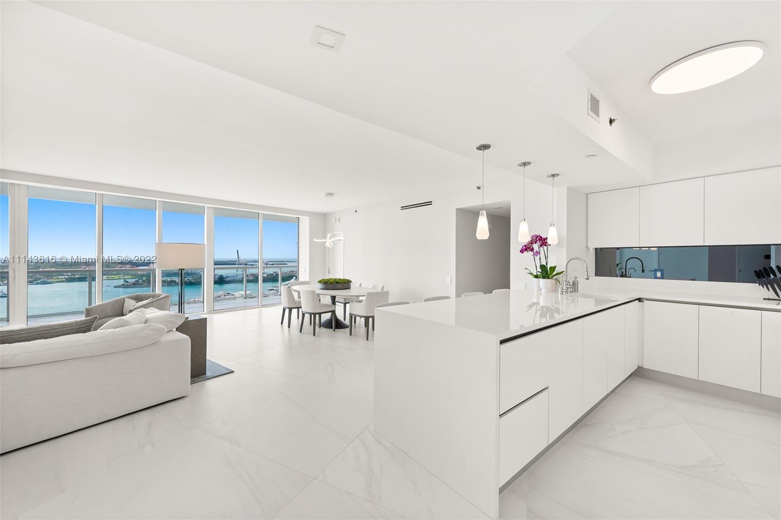 450 Alton Road, Unit 2301 Miami Beach, FL 33139 - Photo 2 of 21 a kitchen with white cabinets and white appliances