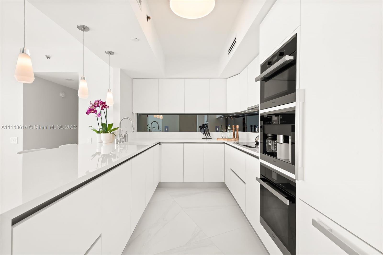 450 Alton Road, Unit 2301 Miami Beach, FL 33139 - Photo 3 of 21 a large white kitchen with lots of counter space