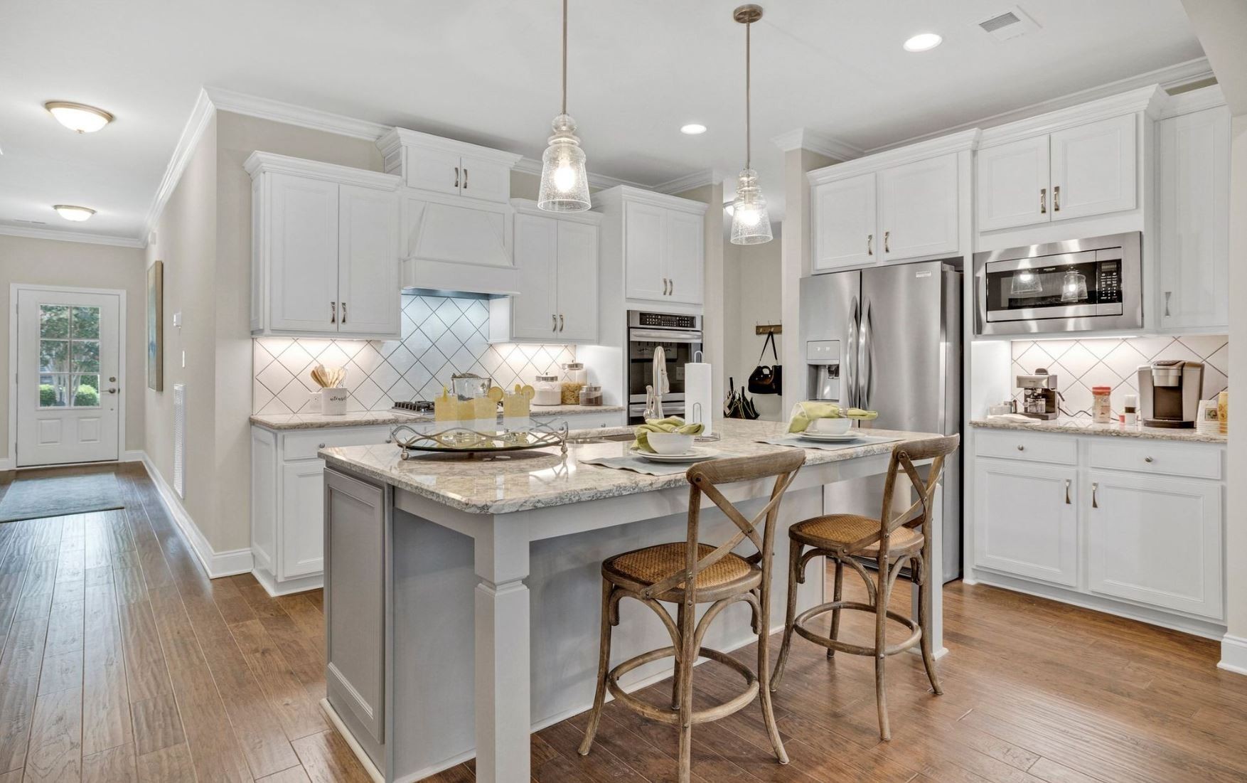 a kitchen with stainless steel appliances granite countertop a table chairs stove refrigerator and cabinets