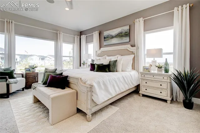 a large bedroom with a bed and large window