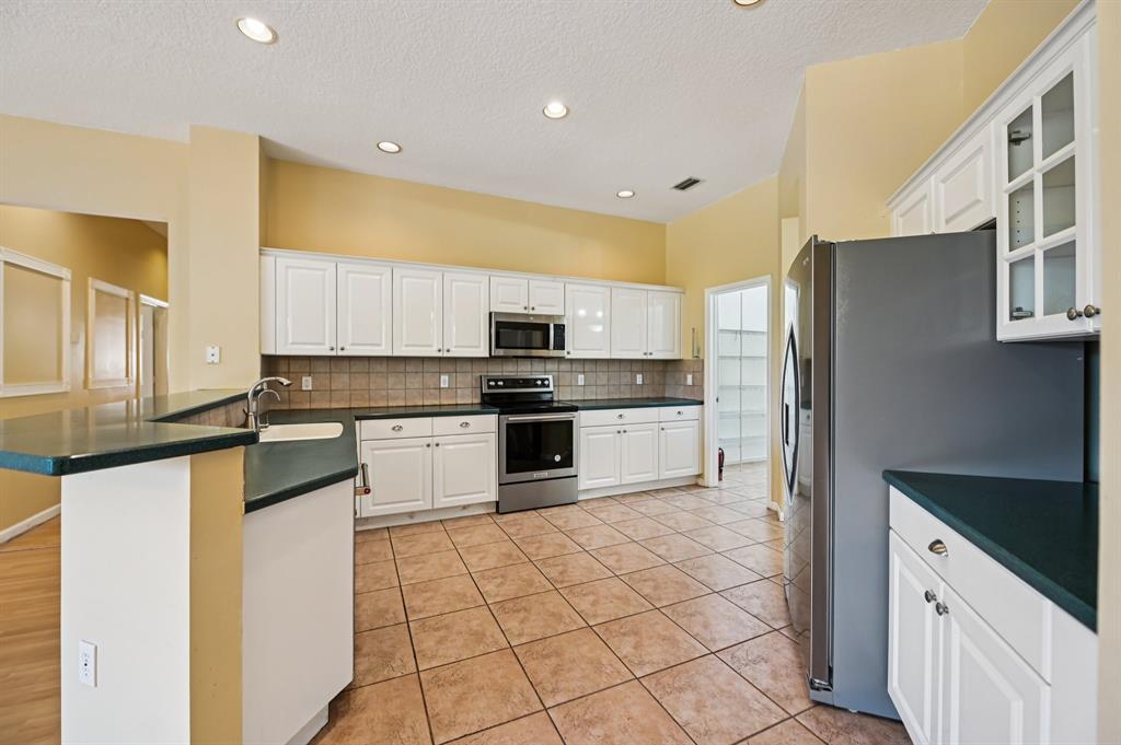 4181 Southwest 141st Avenue Davie, FL 33330 - Photo 12 of 61 a kitchen with stainless steel appliances a refrigerator sink and cabinets