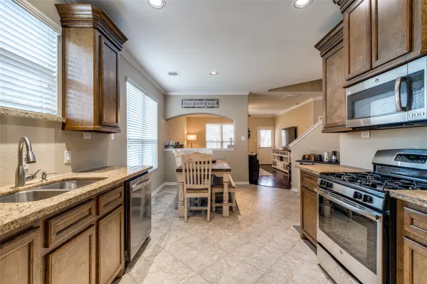 a kitchen with stainless steel appliances granite countertop a sink stove and cabinets