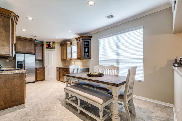 a kitchen with stainless steel appliances kitchen island granite countertop a stove a sink a refrigerator and a dining table