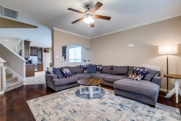 a living room with furniture and a wooden floor