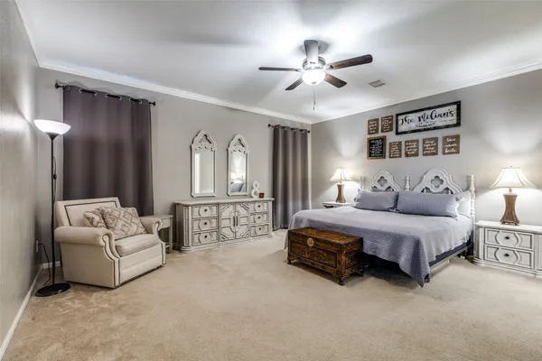 a spacious bedroom with a bed and ceiling fan