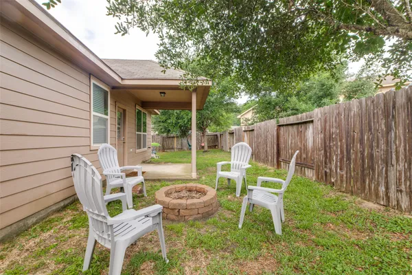 a view of a chair and table in backyard of the house