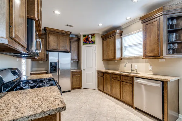 a kitchen with stainless steel appliances granite countertop a sink stove and refrigerator