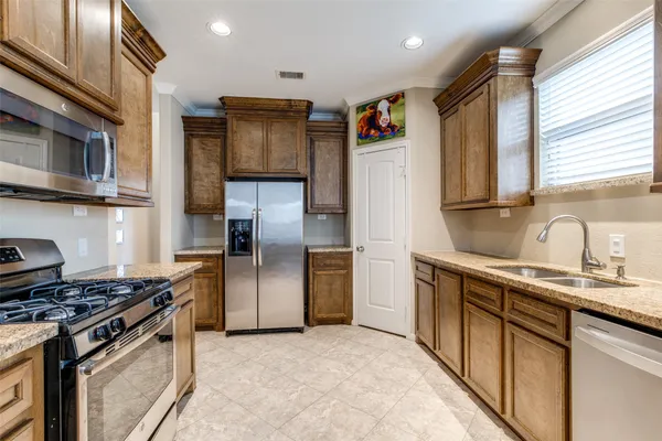 a kitchen with stainless steel appliances granite countertop a sink stove and refrigerator