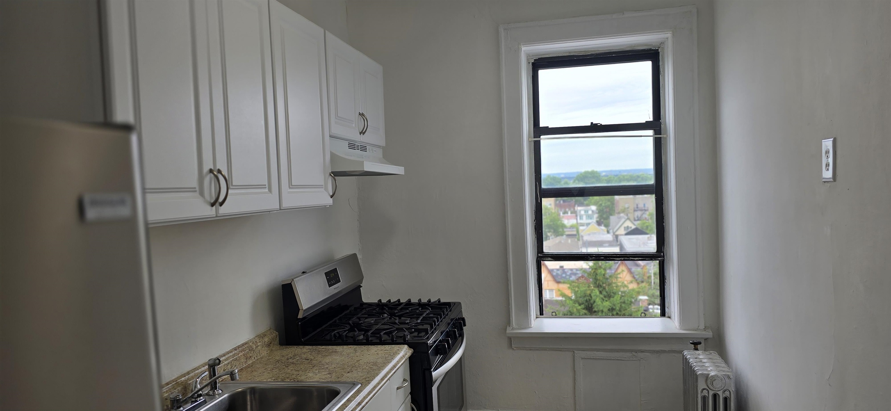 a kitchen with windows and refrigerator