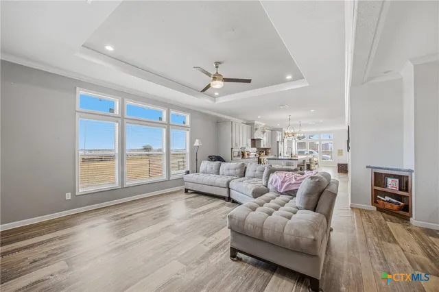 a kitchen with stainless steel appliances granite countertop a dining table chairs and white cabinets