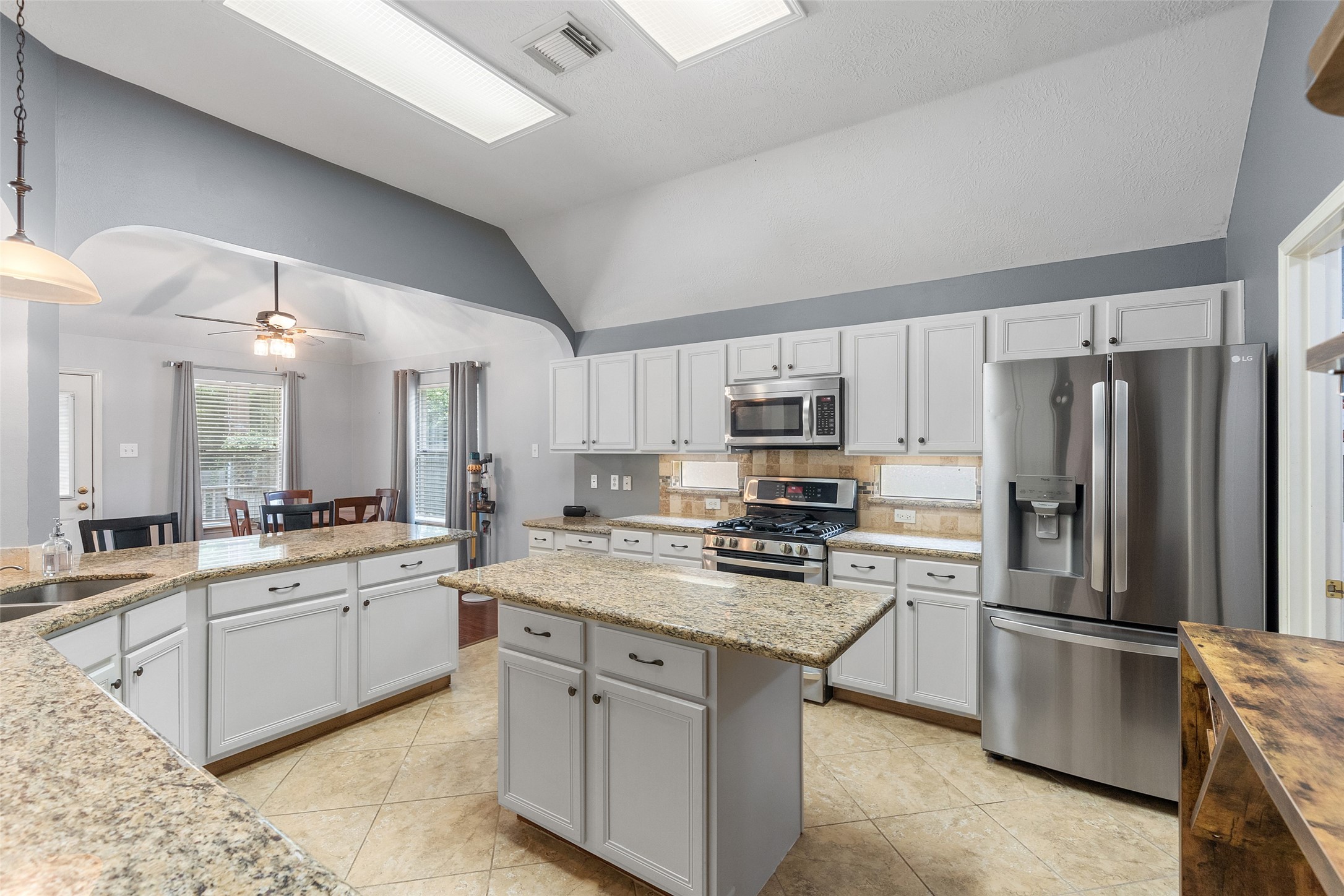 19718 Teller Boulevard Spring, TX 77388 - Photo 19 of 47 a kitchen with stainless steel appliances a sink stove refrigerator and cabinets