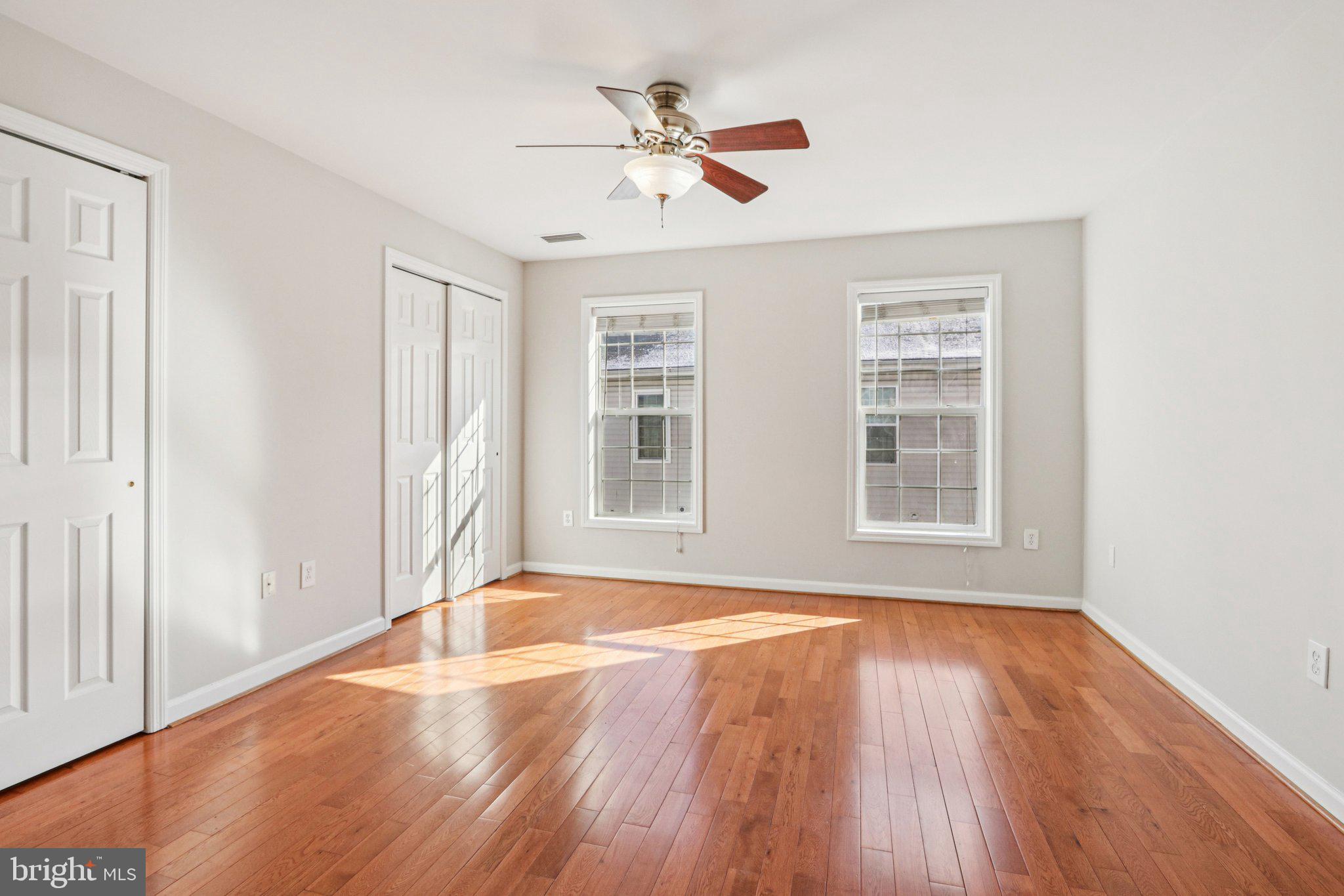 2675 Edgemont Street Philadelphia, PA 19125 - Photo 12 of 18 an empty room with wooden floor chandelier fan and windows