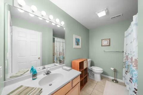a bathroom with a sink vanity granite and toilet