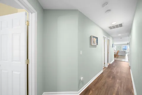 a view of a hallway with wooden floor