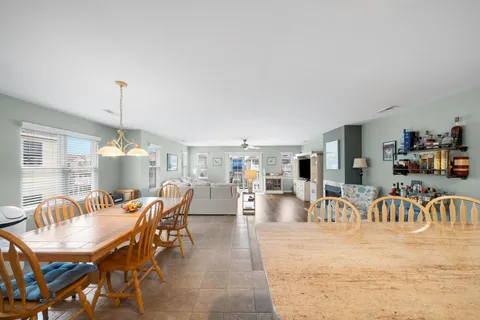 a dining room with furniture a chandelier and window