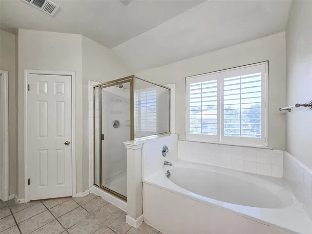 a bathroom with a bathtub shower and windows