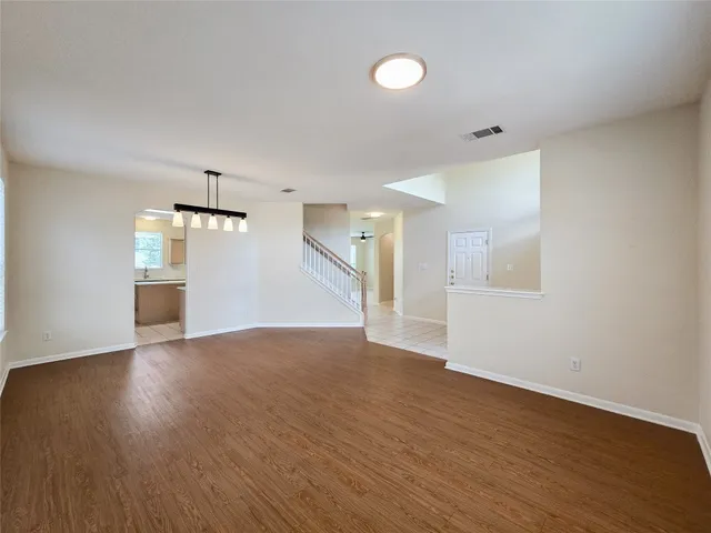 a view of a big room with wooden floor and windows