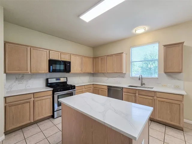 a kitchen with a sink a stove and cabinets