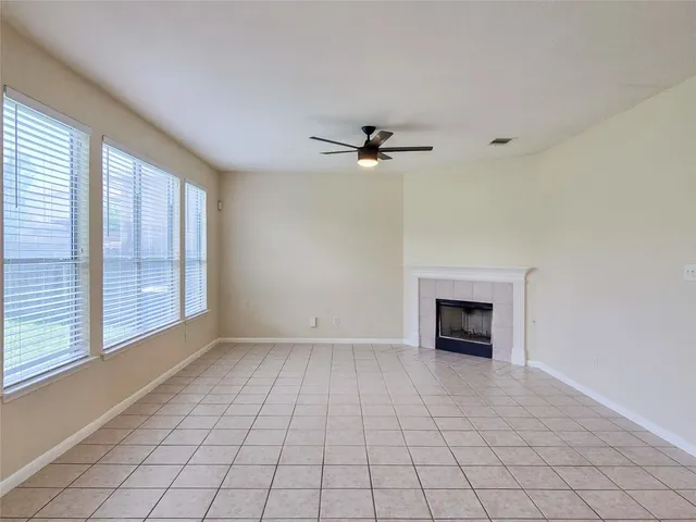 an empty room with windows and fireplace