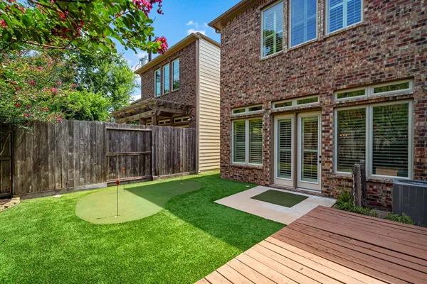 a view of a backyard with table and chairs and wooden fence