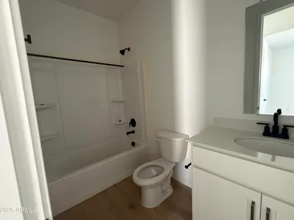 a bathroom with a granite countertop sink a toilet a mirror and shower