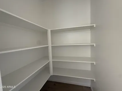 a view of walk in closet with empty racks