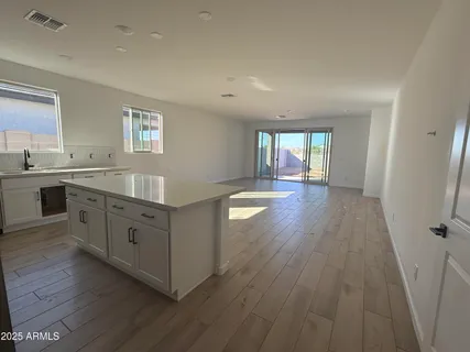 a kitchen with wooden floors and white cabinets