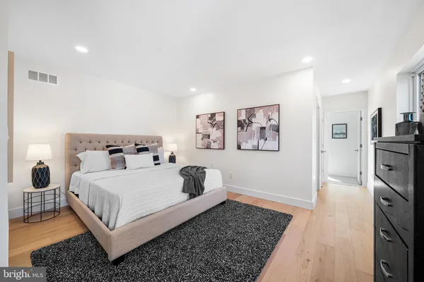 a bedroom with a bed and wooden floor
