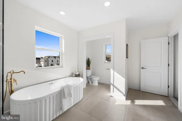 a spacious bathroom with a bathtub and a toilet