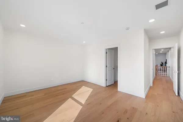 a view of a big room with wooden floor and a bathroom