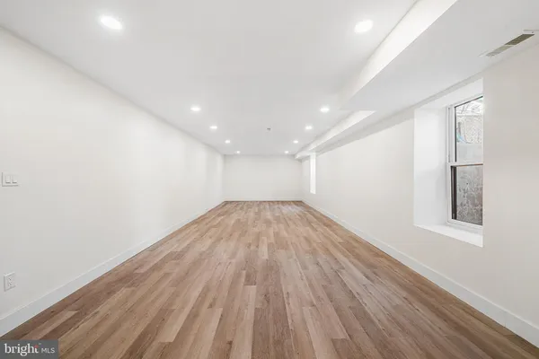a view of empty room with wooden floor