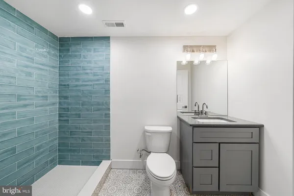 a bathroom with a toilet a sink and mirror