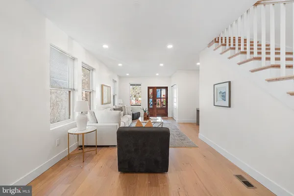 a living room with furniture and a wooden floor