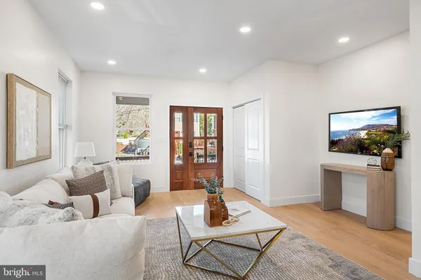 a living room with furniture a flat screen tv and a window