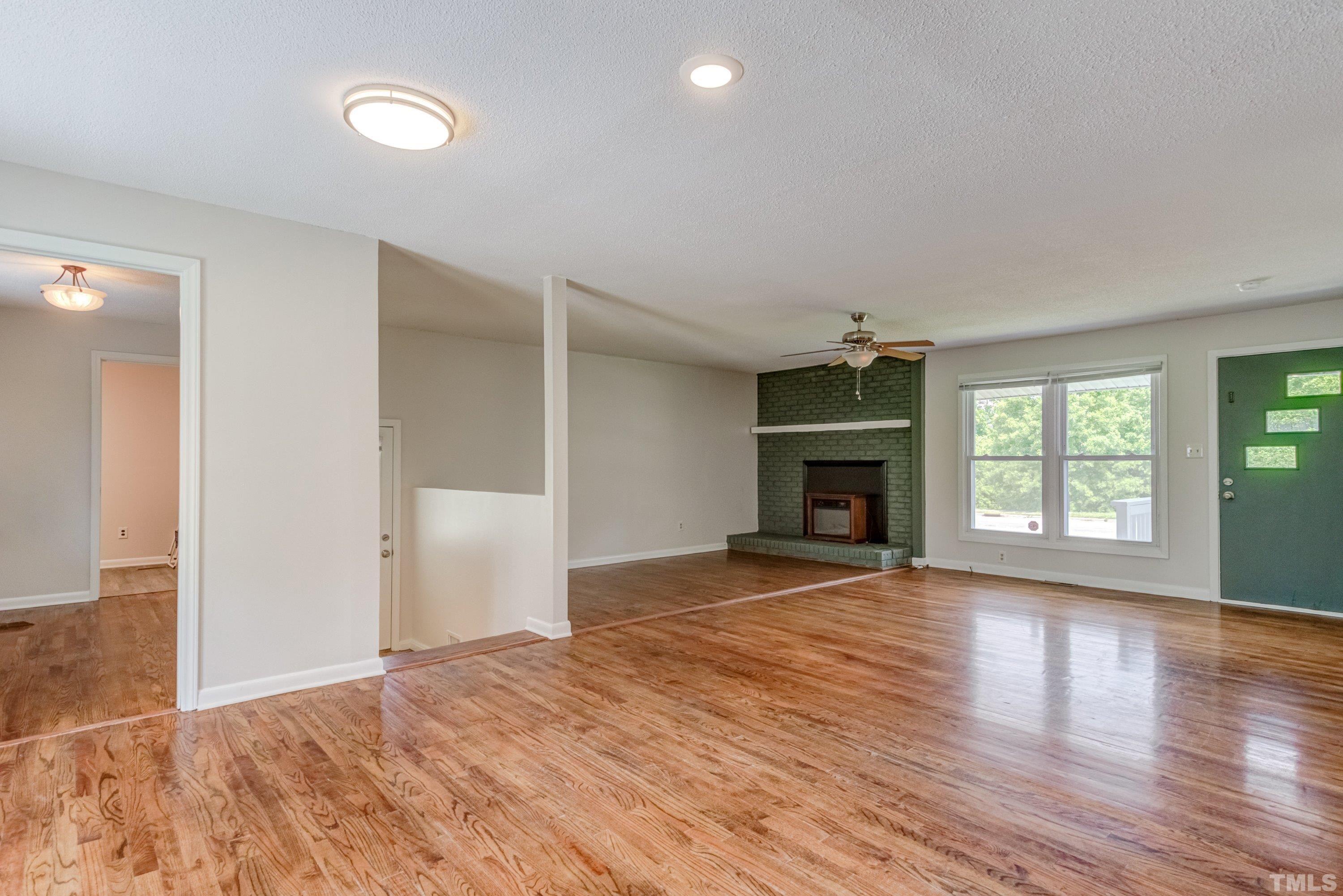 3840 Marsh Creek Road Raleigh, NC 27604 - Photo 32 of 41 an empty room with wooden floor fireplace and windows