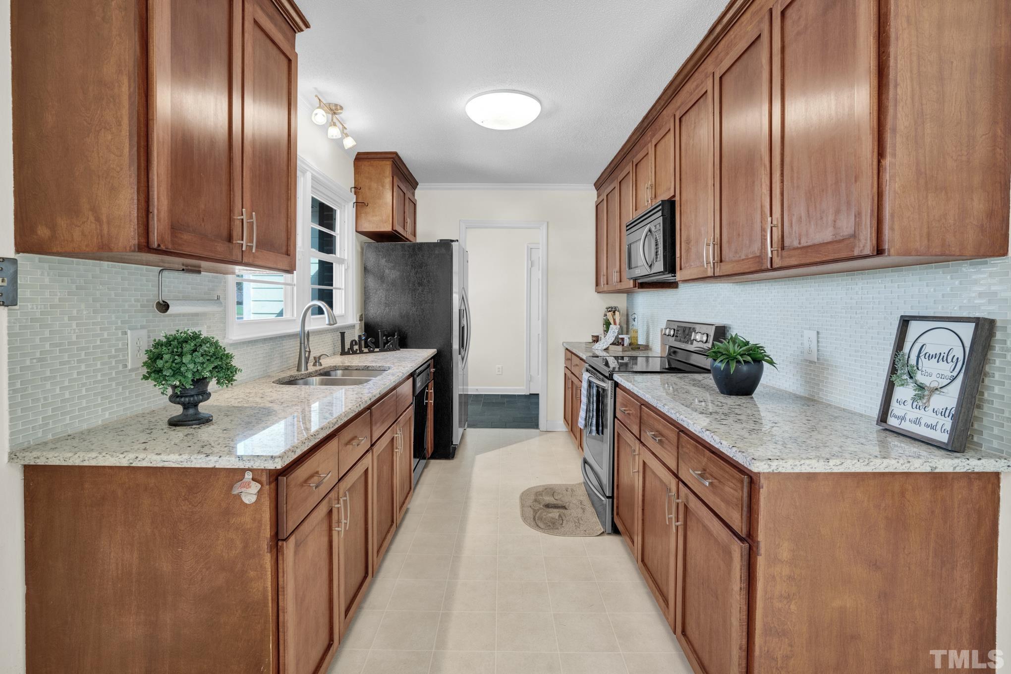 3321 Harden Road Raleigh, NC 27607 - Photo 18 of 26 a kitchen with stainless steel appliances granite countertop granite countertop a sink a stove refrigerator and cabinets