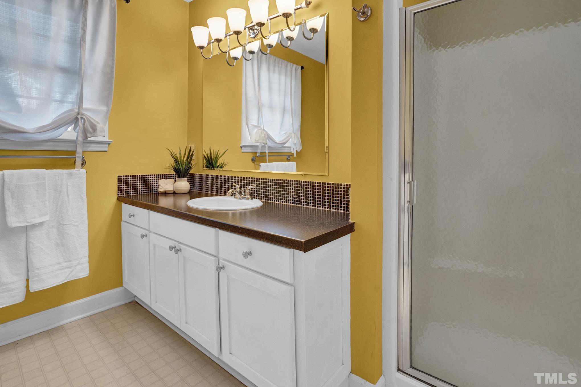 3321 Harden Road Raleigh, NC 27607 - Photo 22 of 26 a bathroom with a granite countertop sink and a mirror